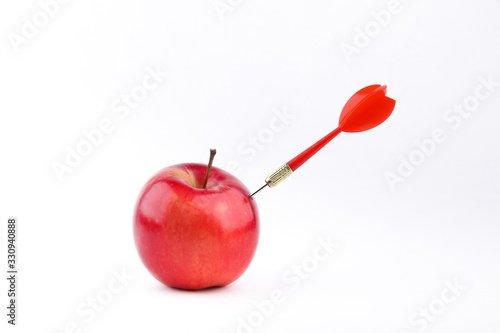 concept of successful work. dart sticks out of an apple on a white background. dart hit an apple on a white background photo