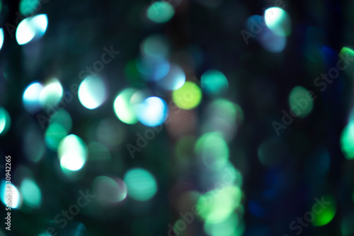 Blurred abstract black background with green and gray lights.