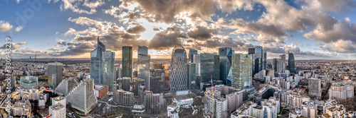 Aerial panoramic drone shot of La defense skyscraper in Paris with clouds and sunset