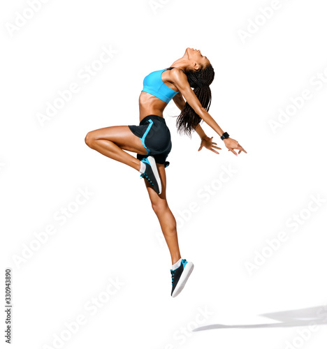 Sporty girl jumping up in silhouette. Photo of african american girl in fashionable sportswear on white background. Dynamic movement. Side view. Full length. Sports and healthy lifestyle © Romario Ien