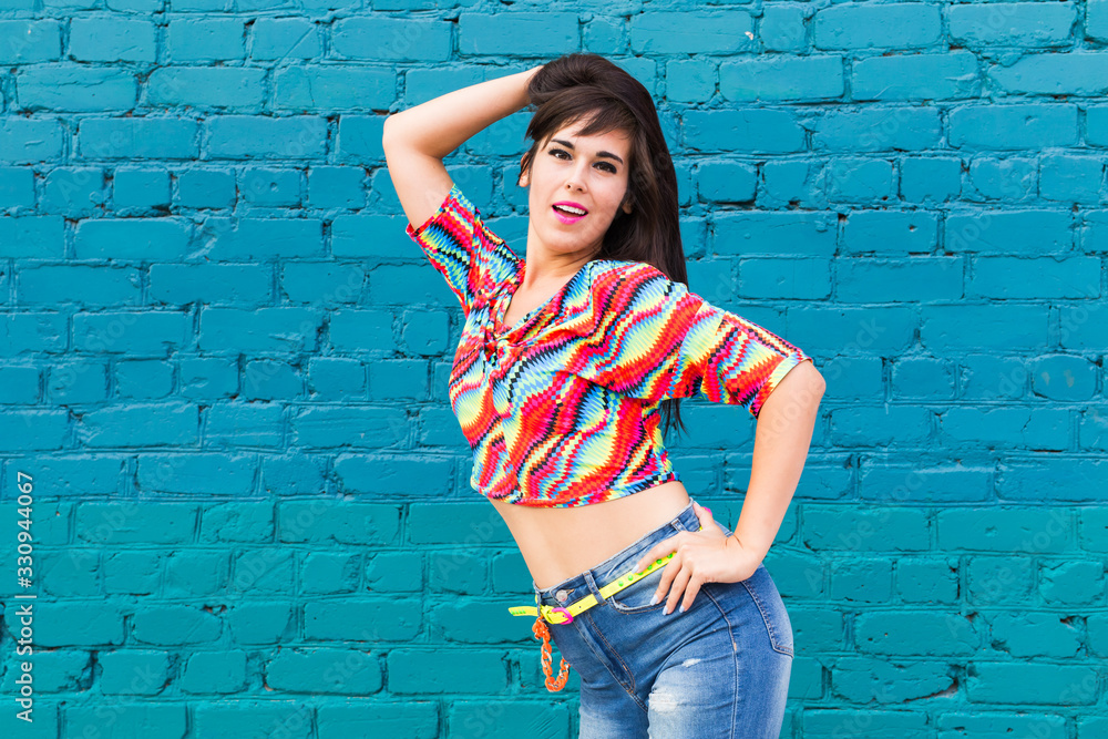 Street shaabi dance and urban dancer concept - Cheerful belly dancer dancing with arabic music on the street, blue brick wall background with copy space Street shaabi dance and urban dancer concept - Cheerful belly dancer dancing with arabic music on the street, blue brick wall background with copy space