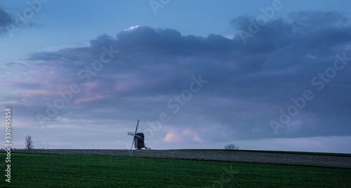 Horebeke East Flanders Belgium. Sunset at field with windmill