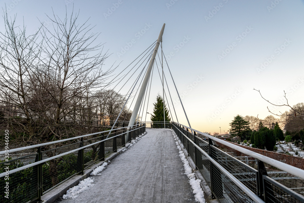A scenic pedestrian bridge next to railway tracks and Lagard cemetery in Stavanger city centre, Norway, December 2017