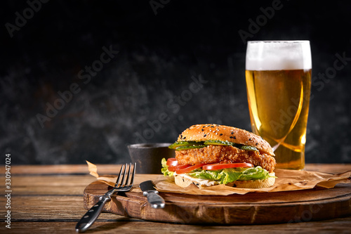 Set of hamburger beer and french fries. A standard set of drinks and food in the pub, beer and snacks. Dark background, fast food. Traditional american food. photo