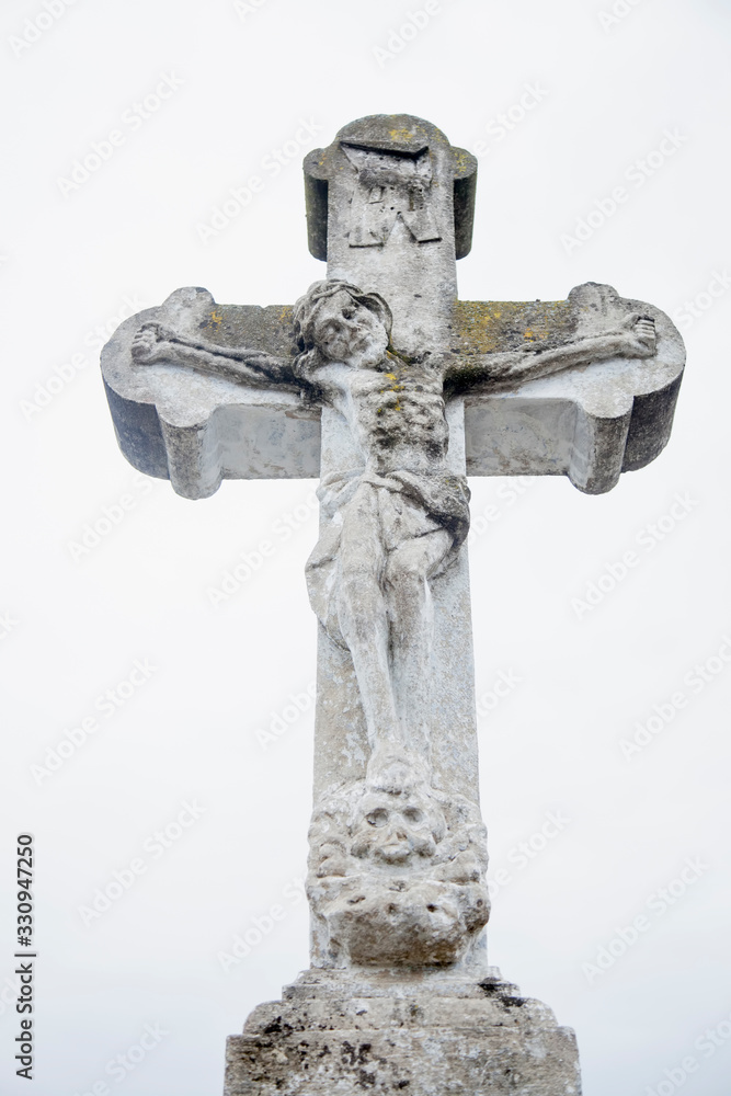 Very ancient stone statue of crucifixion of Jesus Christ. The skull of