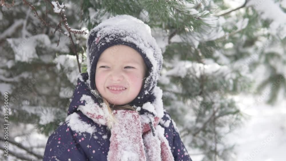 A close-up of a little girl during a winter walk. A small child in the snow A close-up of a little girl during a winter walk. A small child in the snow