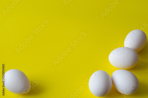 Chicken eggs on yellow background with copy space