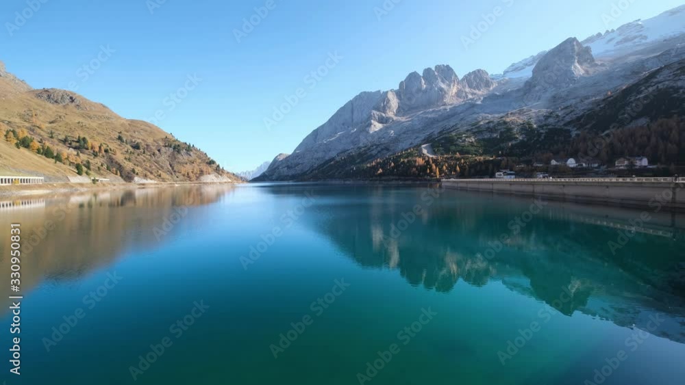 Autumn alpine Fedaia mountain Lake and Pass, Trentino, Dolomites Alps, Italy. Snowy Marmolada massif and Glacier in far right. Autumn alpine Fedaia mountain Lake and Pass, Trentino, Dolomites Alps, Italy. Snowy Marmolada massif and Glacier in far right.