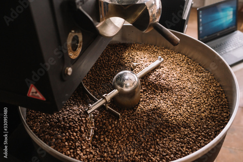 Freshly light roasted arabica coffee beans cooling in a roasters drum with a computer control.