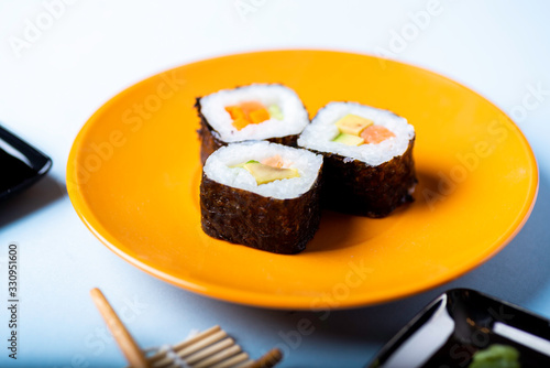 sushi on an orange plate in an overhead view
