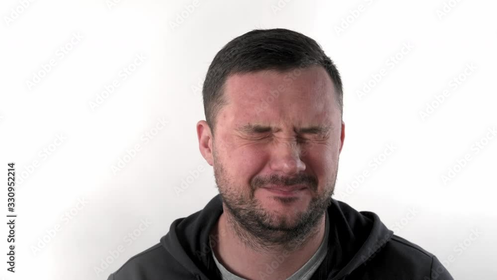 Caucasian brunette man with short hair with a beard in the studio on a white background smiles, speaks strait to the camera and laughs, close-up Caucasian brunette man with short hair with a beard in the studio on a white background smiles, speaks strait to the camera and laughs, close-up