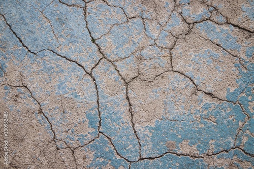 Cracked concrete, rough texture with some azure paint. © dunya8