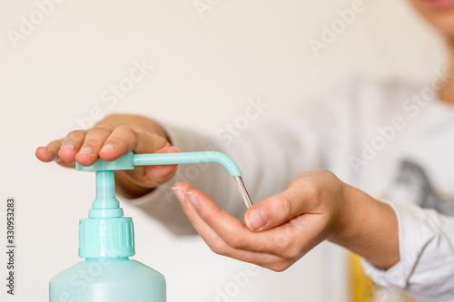 Enfant se lavant les mains avec du gel hydroalcoolique