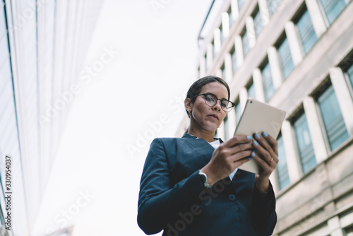 Bild auf Leinwand Focused executive woman working with tablet in downtown