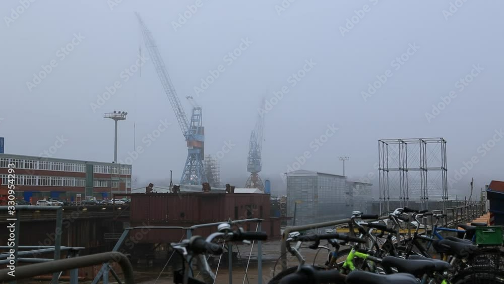 Tracking shot of german shipyard in the fog with bikes in the foreground Tracking shot of german shipyard in the fog with bikes in the foreground