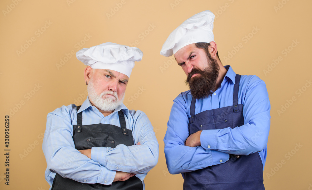 Culinary battle. Mature bearded men professional restaurant cooks competitors. Culinary show. Chef men wear aprons. Father and son culinary hobby. Cafe workers. Culinary industry. Restaurant staff