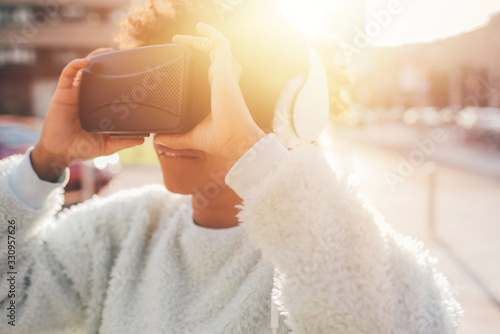 Young mixed race woman outdoor using 3d viewer