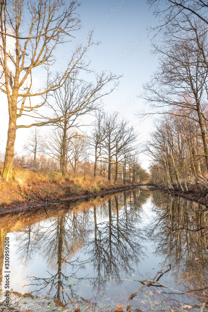 Silhouettes landscape view sunset Water reflection, a canal in a large nature reserve, Fochteloerveen, The Netherlands