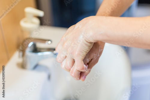COVID-19 , coronavirus , Washing hands with soap under the faucet with water . Hygiene concept.