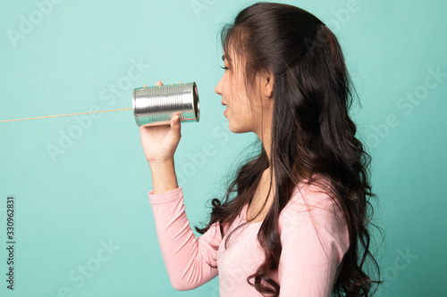 Young Asian woman with tin can phone.