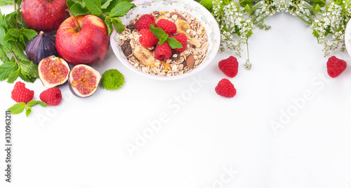  Healthy food background with homemade oatmeal granola or muesli with yogurt and fresh berries for healthy morning breakfast,Muesli, figs, raspberries, apples. top view, copy space. Banner