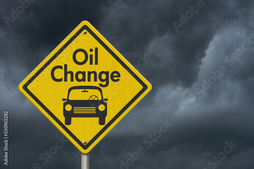 Oil change with car on yellow warning highway road sign