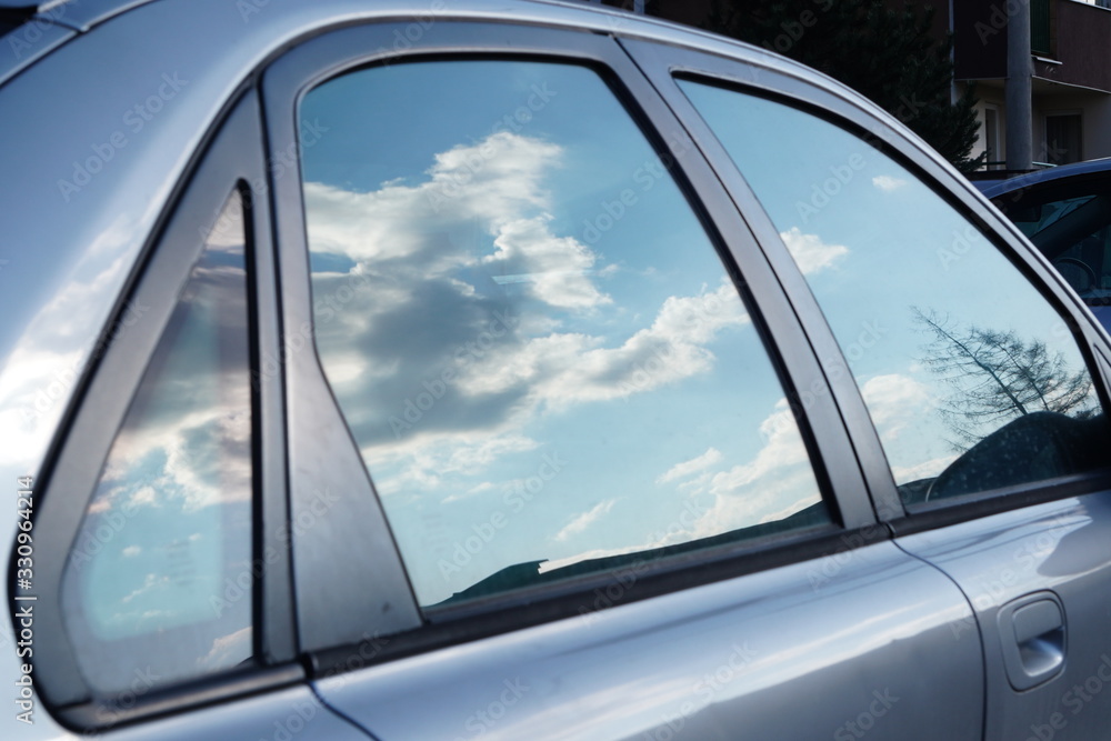 Reflection of the sky and clouds in the window of a car. Blue sky. The clouds Reflection of the sky and clouds in the window of a car. Blue sky. The clouds