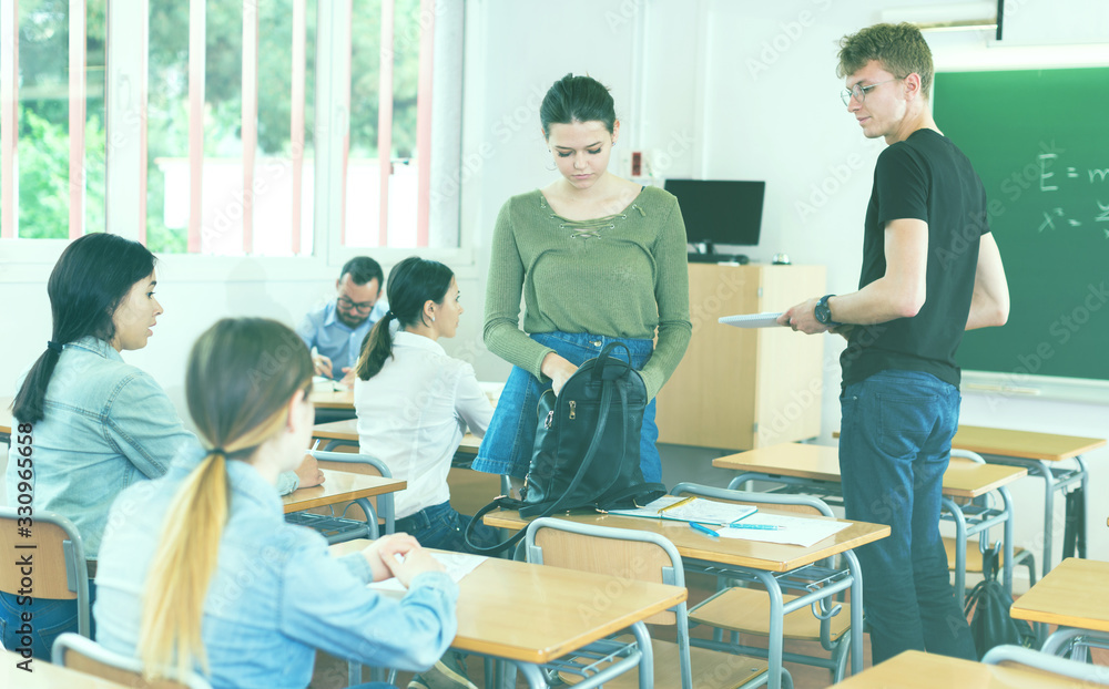 Fototapeta premium Young girls and boys are preparing for lesson with their bags