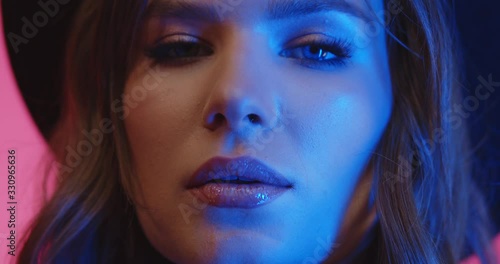 Wallpaper Mural Close up shoot of cheerful stylish brunette girl wearing hat looking in camera in studio in neon lights. Fashion portrait, pink colors with woman. Torontodigital.ca