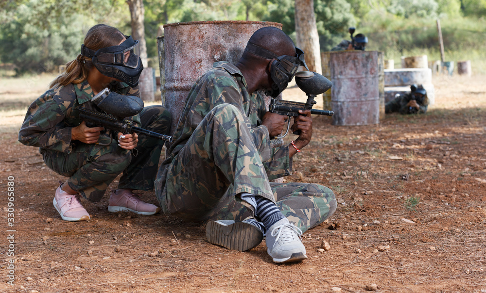 Fototapeta premium Paintball players of opposite teams in shootout