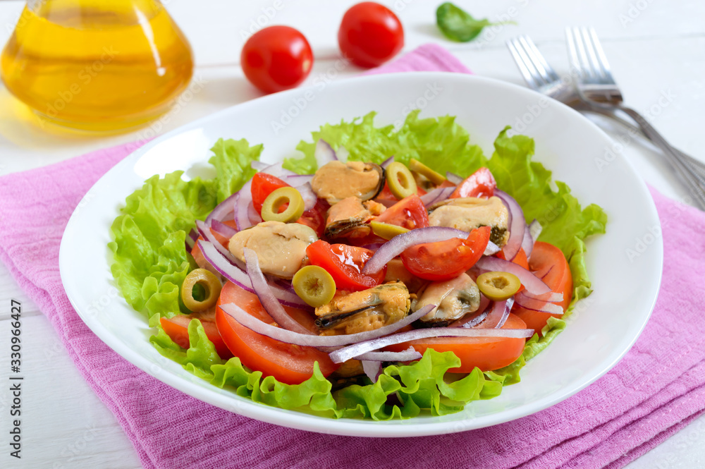 Salad of marinated mussels, fresh tomatoes, red onions, olives in a bowl on a white wooden background