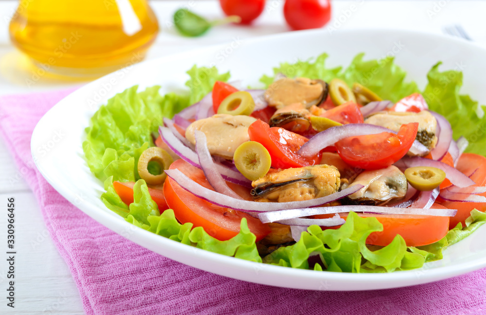 Salad of marinated mussels, fresh tomatoes, red onions, olives in a bowl on a white wooden background Salad of marinated mussels, fresh tomatoes, red onions, olives in a bowl on a white wooden background