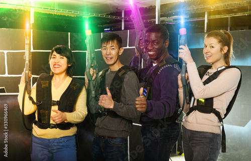 people of different nationalities with laser pistols posing toge