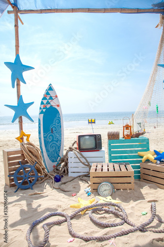 Photo booth setup on beach. Summer, surfing and fishing theme for an event party or birthday.