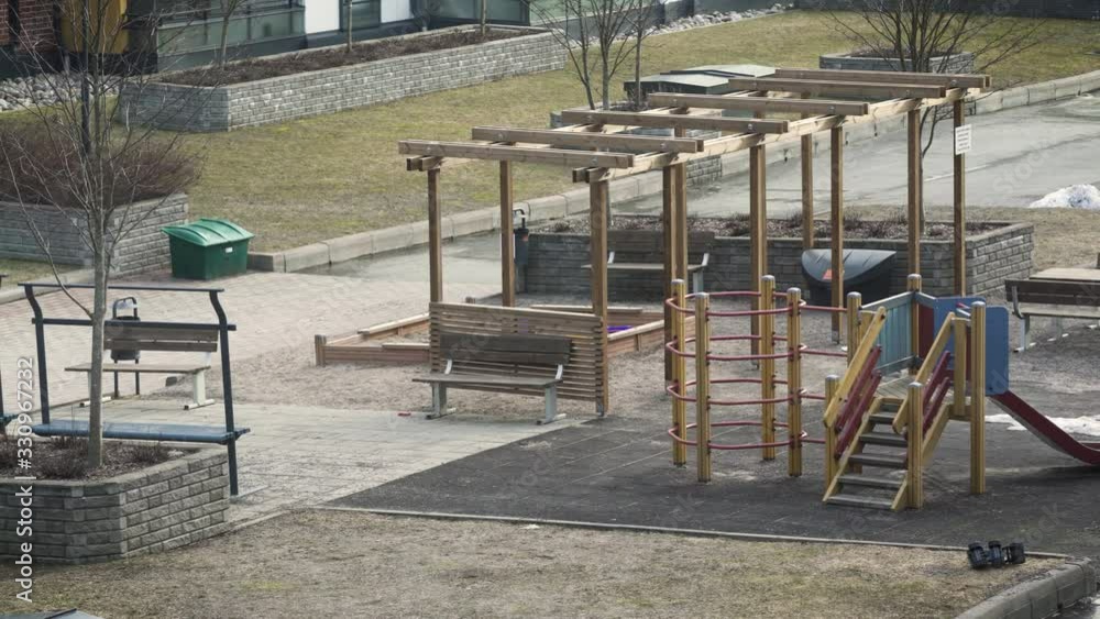 Empty playground during day in urban environment, deserted children's bike and toy lying on the ground [During coronavirus outbreak]