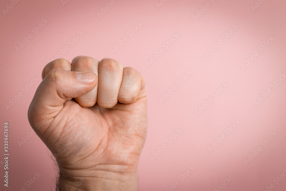 A clenched male fist is up in the air