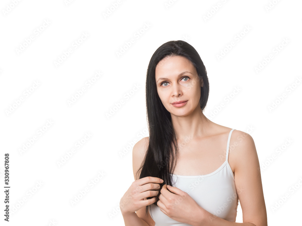 Beautiful caucasian woman touches her long loose black hair with fingers. Female face with well groomed skin and bare shoulders, isolated on white Beautiful caucasian woman touches her long loose black hair with fingers. Female face with well groomed skin and bare shoulders, isolated on white