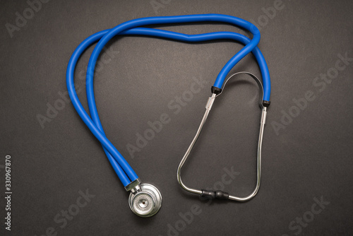 Stethoscope on black background, top view. Medical instrument