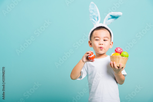 Canvas Print little child boy smile wearing bunny ears and white T-shirt, hold basket with fu