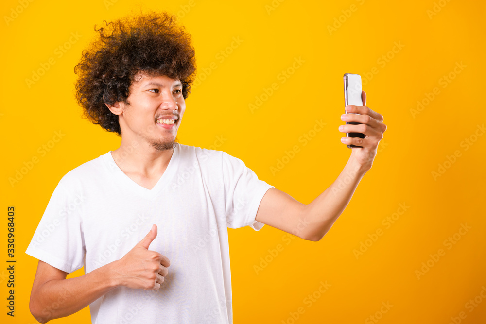 Portrait asian handsome man curly hair taking selfie with mobile phone Portrait asian handsome man curly hair taking selfie with mobile phone