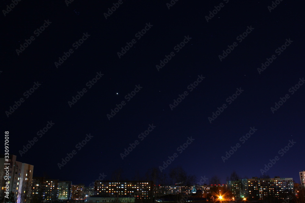 Fototapeta premium Venus among the stars in the night sky over the city
