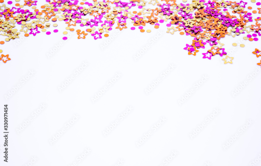 Scattered round confetti and in the form of flowers pink, gold and orange color on a white background. Copy space. Spring and summertime, birthday and wedding concept
