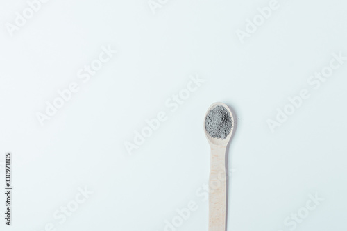 Black clay cosmetic dry powder in wooden spoon