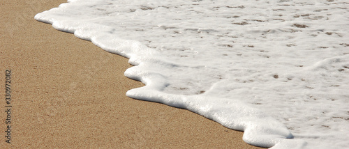 Billede på lærred Bannière d'une douce vague blanche pleine d'écume sur le sable d'une plage de sa