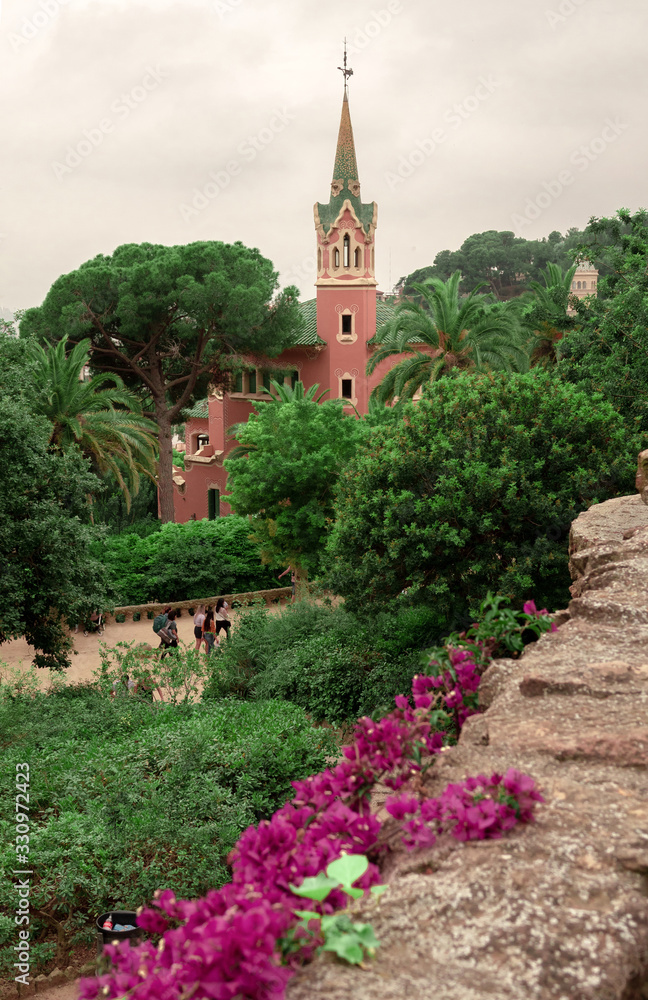 Park Guell Antonio Gaudi with flowering pink bushes. Barcelona, Spain