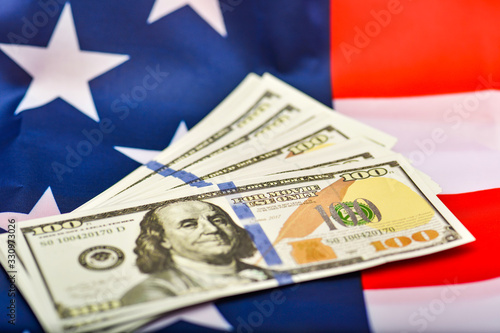 American dollars lie against the backdrop of the US flag, the independence and sustainability of the American economy.