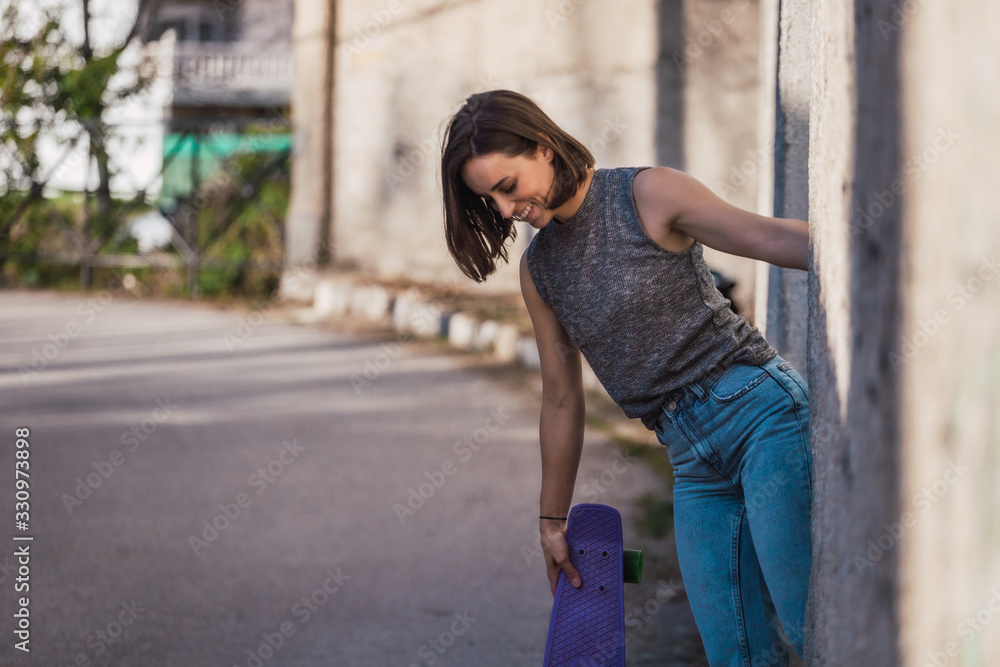 Young woman with blue penny skateboard in casual wearing Young woman with blue penny skateboard in casual wearing