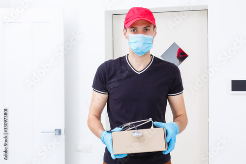 Delivery man holding cardboard boxes in rubber gloves and medical mask. copy space. Fast and free Delivery transport . Online shopping and Express delivery photo