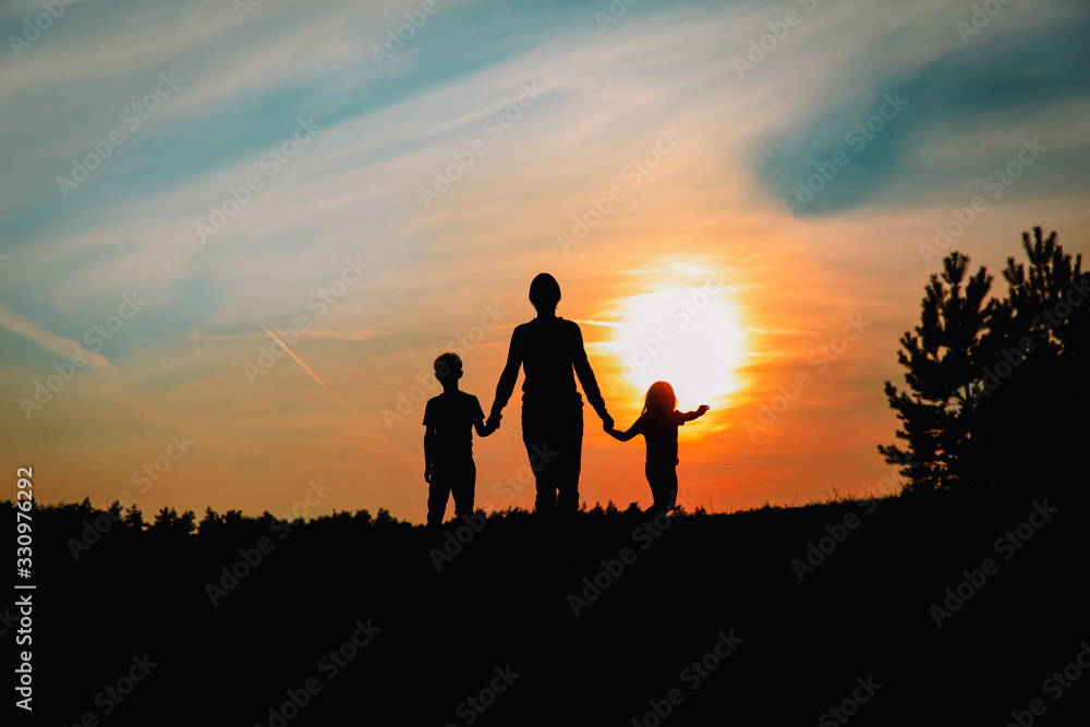 father with son and daughter walk at sunset