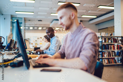Photography Delighted fellows browsing computers in library